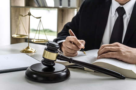 Law, lawyer attorney and justice concept, male lawyer or notary working on a documents and report of the important case in the workplace office.の写真素材