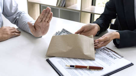 Businessman refuse receive bribe money the form of dollar bills from woman while give success the deal, Bribery and anti-corruption concept.の写真素材