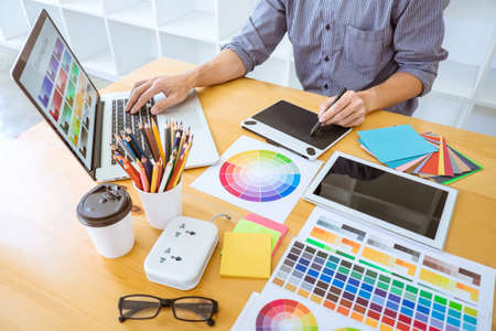 Young creative graphic designer working on project architectural drawing and color swatches,...