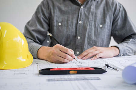 Construction engineering or architect hands working on blueprint inspection in workplace, while checking information drawing and sketching for architecture project working.の写真素材