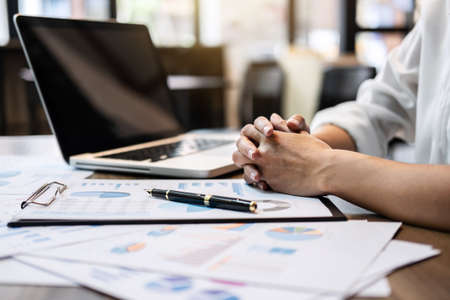 Business woman accountant working audit and calculating expense financial annual financial report balance sheet statement, doing finance making notes on paper checking document.の写真素材