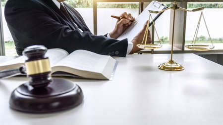 Law, lawyer attorney and justice concept, male lawyer or notary working on a documents and report of the important case in the workplace office.の写真素材