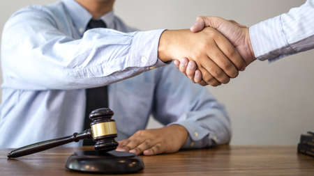 Handshake after consultation between a male lawyer and client, giving advice and prosecutions about the regarding real estate.の写真素材