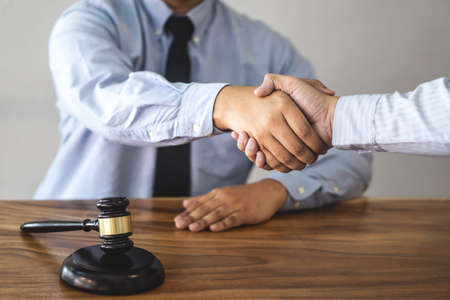 Handshake after consultation between a male lawyer and client, giving advice and prosecutions about the regarding real estate.の写真素材