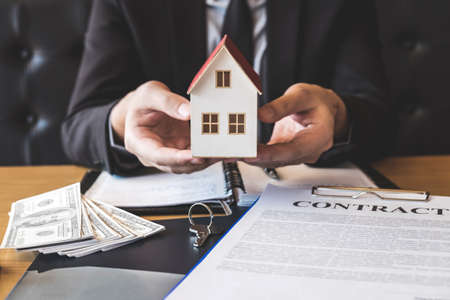 Estate agent sending house model to client after signing agreement contract real estate with...