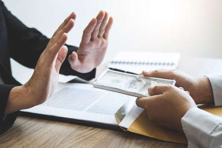 Anti bribery and corruption concept, Business man refusing and don't receive money banknote offered from business people to accept agreement contract of investment deal.の写真素材