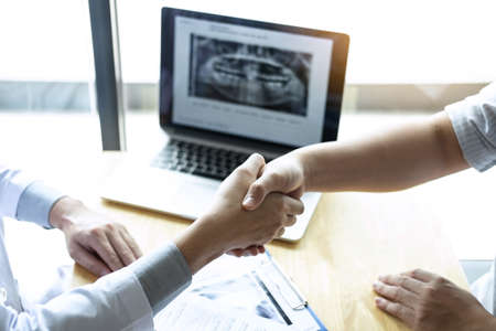 Doctor having shaking hands with patient after recommend treatment method while discussing explaining his symptoms or counsel diagnosis health, healthcare and assistance concept.の写真素材