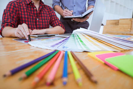 Team of Creative graphic designer meeting working on new project, choose selection color and drawing...