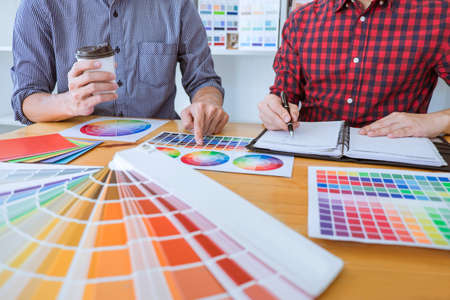 Team of Creative graphic designer meeting working on new project, choose selection color and drawing on graphics tablet with work tools and accessories.の写真素材