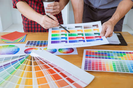 Team of Creative graphic designer meeting working on new project, choose selection color and drawing...