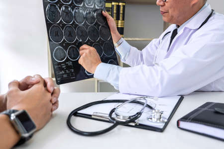 Professor Doctor having conversation with patient and holding x-ray film while discussing explaining...