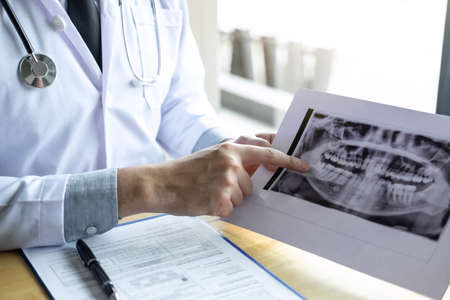 Image of doctor or dentist working with tooth x-ray film in the treatment of dental and dentistry,...