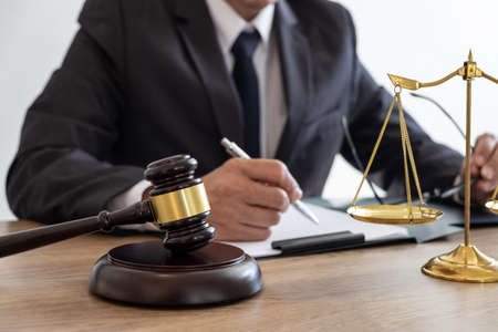 Law, lawyer attorney and justice concept, male lawyer or notary working on a documents and report of the important case in the law firm.の写真素材