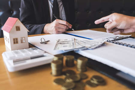 Estate agent broker presenting and wait to client after signing agreement contract real estate with approved application form, buying or concerning mortgage loan offer for and house insurance.の写真素材