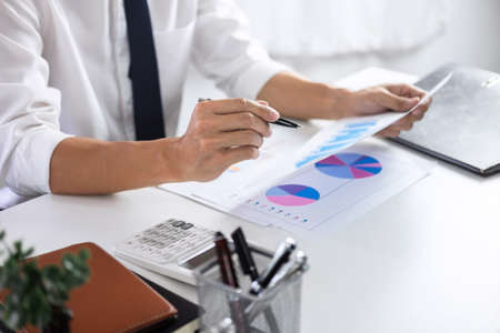 Businessman accountant working audit and calculating expense financial data on graph documents,...