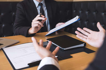 Employer or recruiter holding reading a resume during about his profile of candidate, employer in...