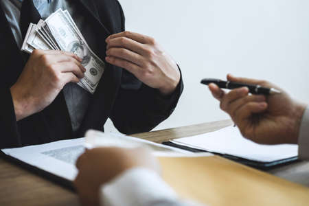 Dishonest cheating in business illegal money, Businessman receive bribe money in business people to give success the deal contract of investment, Bribery and corruption concept.の写真素材