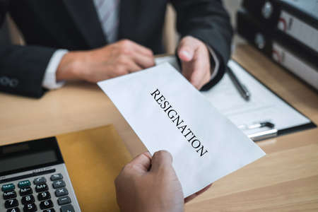 Businessman sending a resignation letter to employer boss in order to resign dismiss contract, changing and resigning from work concept.の写真素材