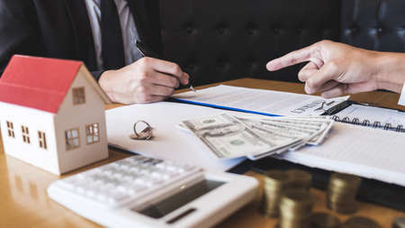 Estate agent broker presenting and wait to client after signing agreement contract real estate with approved application form, buying or concerning mortgage loan offer for and house insurance.の写真素材