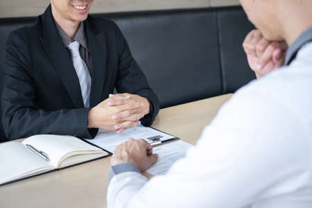 Employer arriving for a job interview, businessman listen to candidate answers explaining about his profile and colloquy dream job, manager sitting in job Interview talking in office.の写真素材