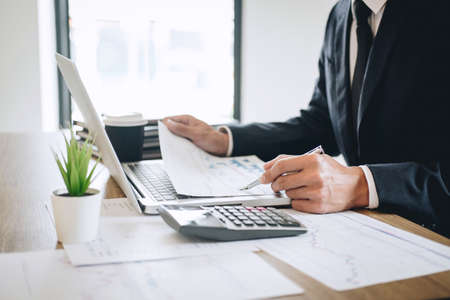 Businessman working new project on laptop computer with report document and analyze, calculating...