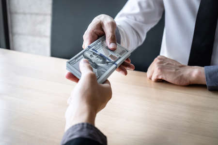 Dishonest cheating in business illegal money, Businessman receive bribe money in envelope to business people to give success the deal contract of investment, Bribery and corruption concept.の写真素材