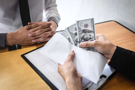 Dishonest cheating in business illegal money, Businessman giving bribe money in envelope to business...