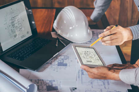Construction engineering or architect discuss a blueprint while checking information on drawing and sketching, meeting for architectural project of partner.の写真素材