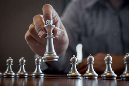 Gold and silver chess with player, Intelligent businessman playing chess game competition to planning business strategic to development for win and success.の写真素材