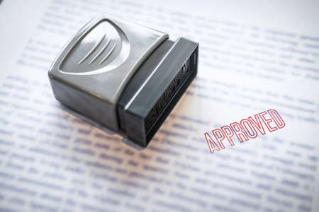 Close up stamp on paper document to approve business investment contract agreement.の写真素材