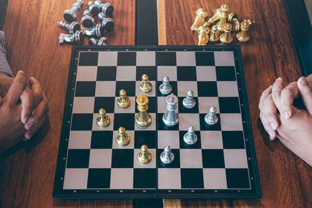 Intelligent businessman playing chess game competition with the opposite team, planning business...