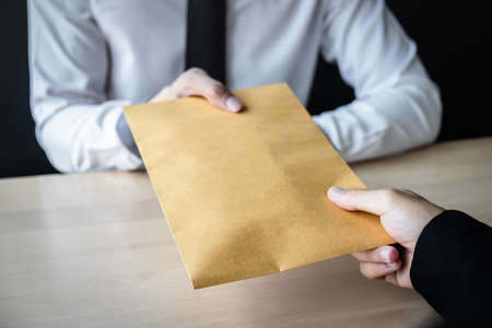 Dishonest cheating in business illegal money, Businessman giving bribe money in envelope to business people to give success the deal contract of investment, Bribery and corruption concept.の写真素材