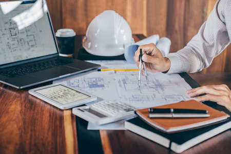 Construction engineering or architect hands working on blueprint inspection in workplace, while checking information drawing and sketching for architecture project working.の写真素材