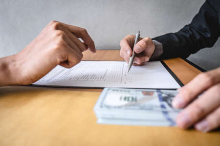 Dishonest cheating in business illegal money, Businessman receive bribe money in envelope to business people to give success the deal contract of investment, Bribery and corruption concept.の写真素材