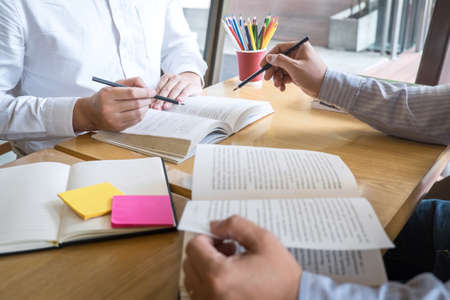 Tutor, learning, education, Group of teenager learning studying new lesson to knowledge in library during helping teaching friend education prepare for exam, youth campus friendship teens concept.の写真素材