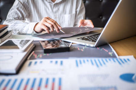 Stock exchange market concept, Business investor trading or stock brokers having a planning and analyzing with display screen and pointing on the data presented and deal on a stock exchange.の写真素材