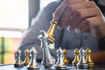 Gold and silver chess with player, Intelligent businessman playing chess game competition to planning business strategic to development for win and success.の写真素材