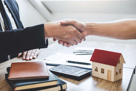 Finishing to successful deal of real estate, Broker and client shaking hands after signing contract approved application form, concerning mortgage loan offer for and house insurance.の写真素材