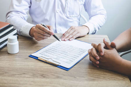 Doctor having conversation with patient while discussing explaining symptoms or counsel diagnosis health and consult treatment of disease, healthcare and assistance concept.の写真素材