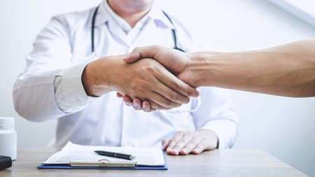 Doctor having shaking hands to congrats with patient after recommend treatment while discussing explaining his symptoms and counsel diagnosis health, healthcare and assistance concept.の写真素材