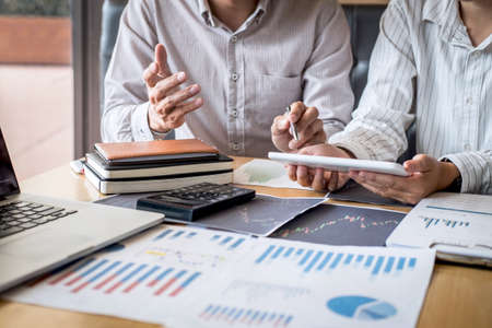 Stock exchange market concept, Team of investment trading or stock brokers having a consultation and analyzing with display screen and pointing on the data presented and deal on a stock exchange.の写真素材
