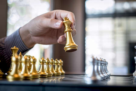 Gold and silver chess with player, Intelligent businessman playing chess game competition to planning business strategic to development for win and success.の写真素材