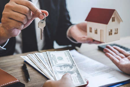 Estate agent broker receive money from client after signing agreement contract real estate with approved mortgage application form, buying or concerning mortgage loan offer for and house insurance.の写真素材