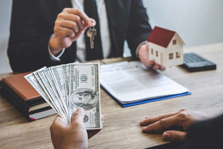 Estate agent broker receive money from client after signing agreement contract real estate with approved mortgage application form, buying or concerning mortgage loan offer for and house insurance.の写真素材