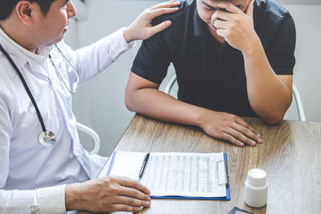 Image of doctor holding patient's hand to encourage, talking with patient cheering and support.の写真素材