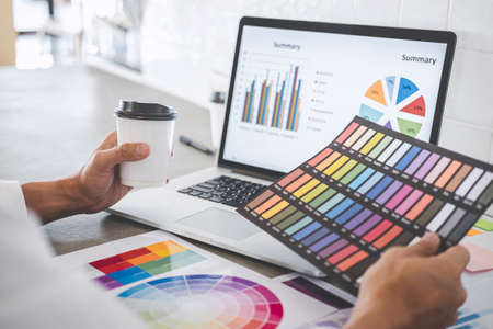 Young creative graphic designer working on project architectural drawing and color swatches,...