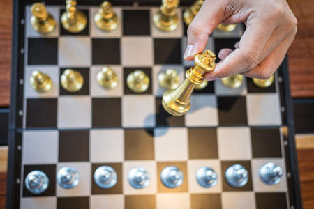 Gold and silver chess with player, Intelligent businessman playing chess game competition to...