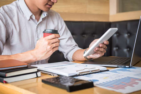 Businessman working investment project on laptop computer with report document and analyze, calculating financial data on graph documents, doing finance making statistics.の写真素材