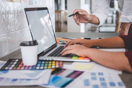Teamwork of young creative designers working on project together and choose color samples for...