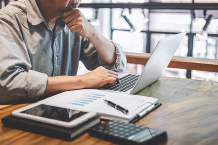 Senior professional businessman in casual wear working using laptop in cafe with business working...